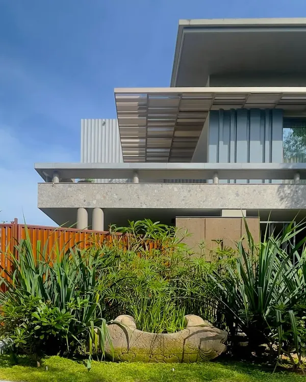 The 'STILL HOME' in Tiruppur, where shades of grey create a sense of peace and stillness. The design uses a rich palette of textures, including exposed concrete, GFRC panels, and corten steel, all unified by a monochrome theme.