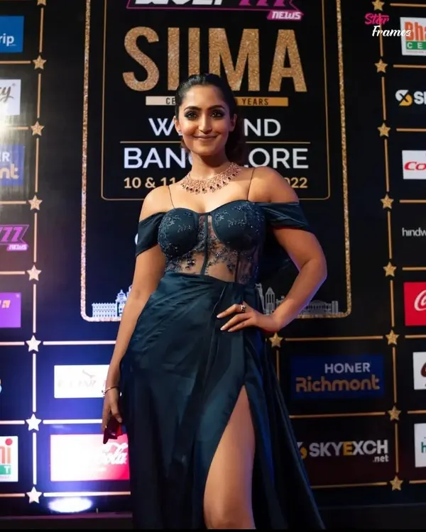 A custom-designed navy blue corset gown created for actress Reba John for the SIIMA Awards. This piece features an off-shoulder design with delicate lacework on the bodice and a draped satin skirt with a high slit, perfect for a red carpet statement.