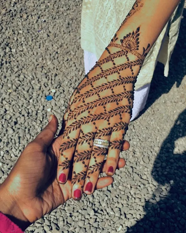 A very modern and elegant design featuring a net of delicate leafy vines covering the back of the hand.