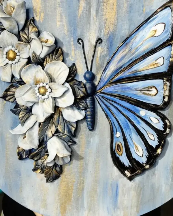 A stunning example of canvas sculpting, where a butterfly's wing is painted and the other is crafted from 3D floral elements. Learn to combine painting and sculpting in our mixed-media workshops.