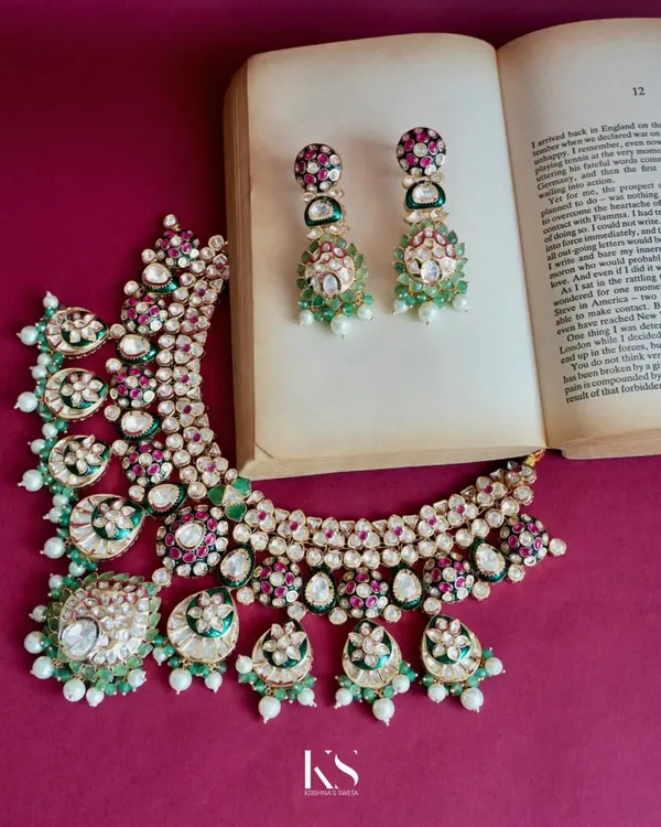 A statement Kundan set that pulls an entire outfit together. The combination of uncut stones, emeralds, rubies, and pearls creates a rich, traditional look that is perfect for any festive or wedding occasion.