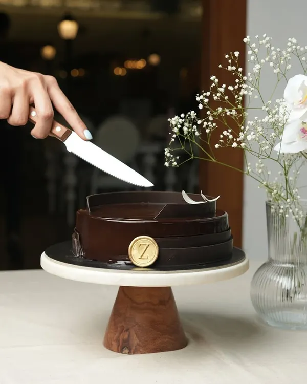 The moment before the first slice. My Belgium Chocolate Cake, with its glossy finish and elegant chocolate collar, sits ready to be the star of your celebration.