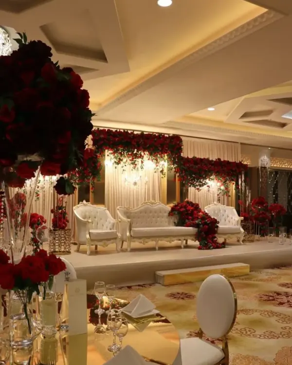 This reception stage exudes pure royalty. I used a classic all-white theme for the seating and backdrop, contrasted with dramatic deep-red rose arrangements. The result is a look that is both timeless and incredibly luxurious.
