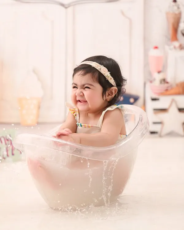 The pure joy of splashing in a warm milk bath. This little one's scrunched-up, happy face is absolutely infectious.