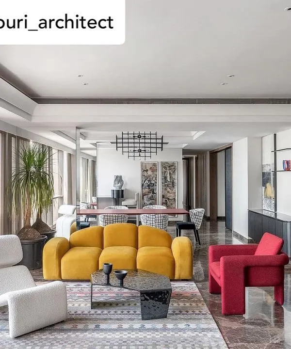 A panoramic view of a sea-facing Mumbai residence where our furniture creates a dialogue between art and design. This living space features our vibrant yellow sofa, a sculptural red armchair, and a free-flowing white lounge chair, all set against the backdrop of the city skyline.