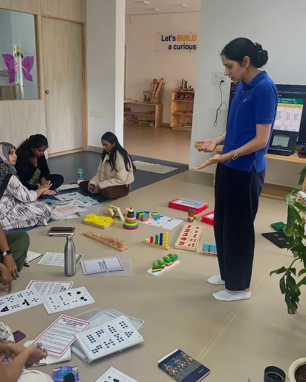 I believe the best learning happens when we are actively engaged. Here, I am guiding a group of passionate educators through a hands-on early numeracy workshop, using tangible materials to explore concepts like subitizing and pattern recognition in a collaborative floor-based setting.