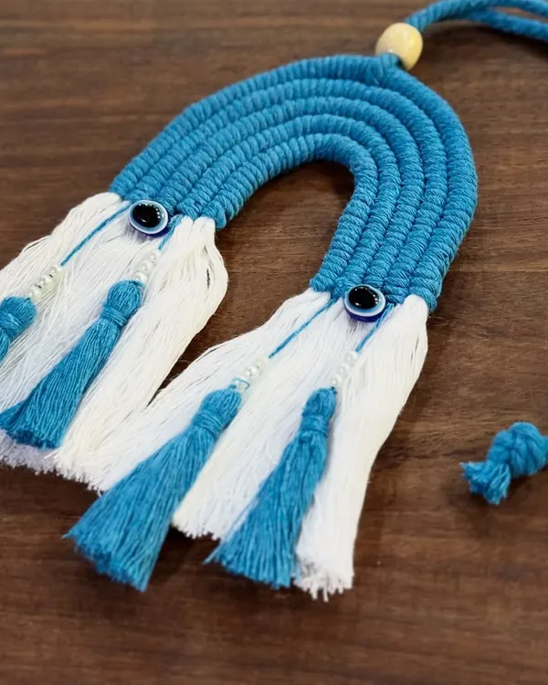 My blue rainbow car charm with evil eye details. It's a beautiful and protective accessory for your car, handcrafted with macrame.