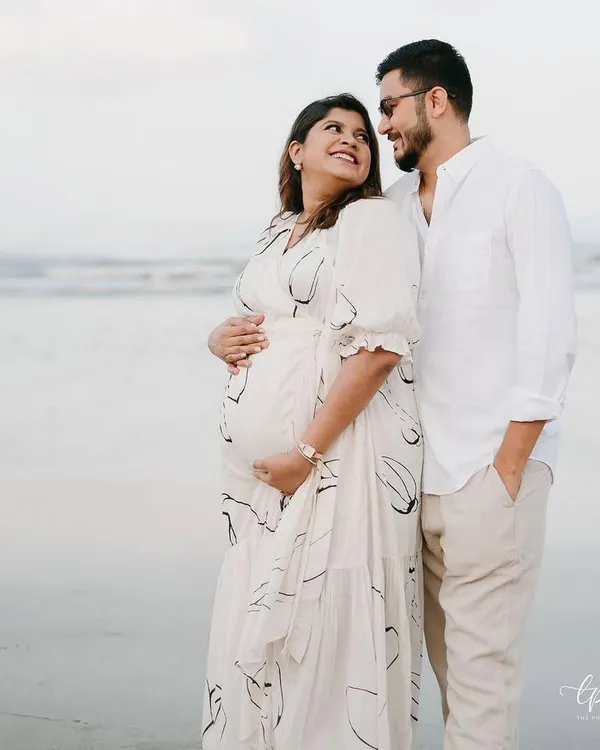 A beautiful, serene moment from a maternity shoot on the beach. The makeup is soft, natural, and radiant, designed to enhance her glow and look beautiful in the soft, natural light.