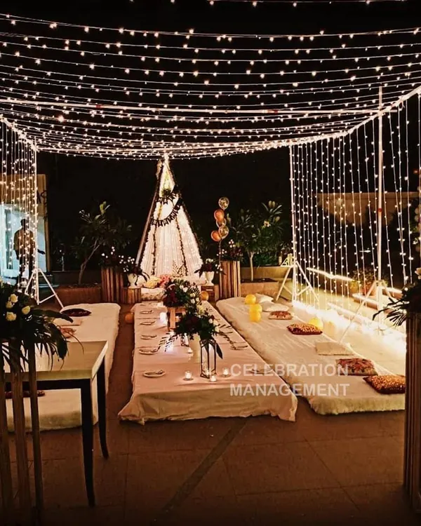 We create magical evenings with our signature terrace decoration. This setup features a canopy of fairy lights and cozy low seating, perfect for an intimate birthday dinner or a romantic surprise.