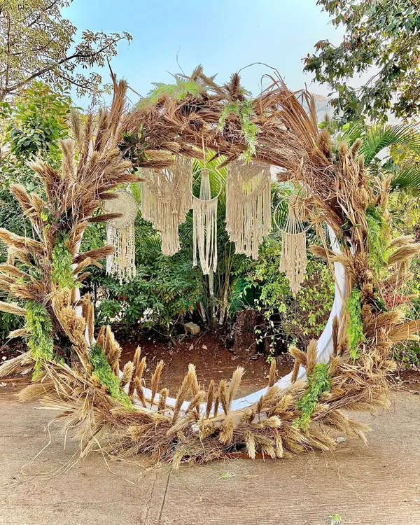 A stunning bohemian-style circular arch, perfect for a photobooth or a mandap. We used a mix of dried pampas grass, twigs, and macrame dreamcatchers to create this earthy and artistic installation.