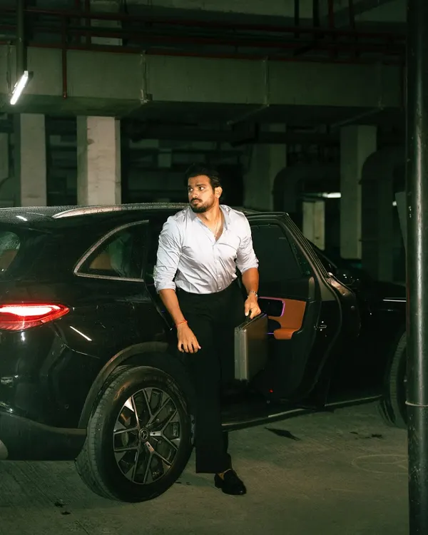 A cinematic shot in an underground parking lot, using the ambient light and a luxury car to build a narrative of suspense and style.
