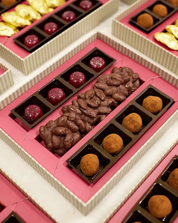 Elevate your corporate gifting with our bespoke chocolate boxes. This arrangement features an assortment of our Belgian truffles, chocolate almond bark, and gold-wrapped rochers.