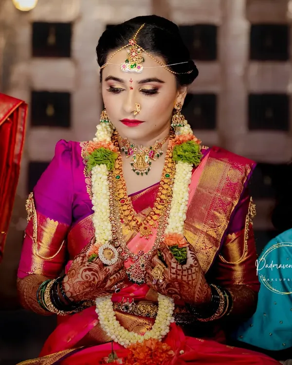 This is the essence of a South Indian muhurtham look. I focused on creating luminous, long-lasting skin that glows, paired with classic eye makeup and a bold red lip to perfectly complement her temple jewelry and silk saree.