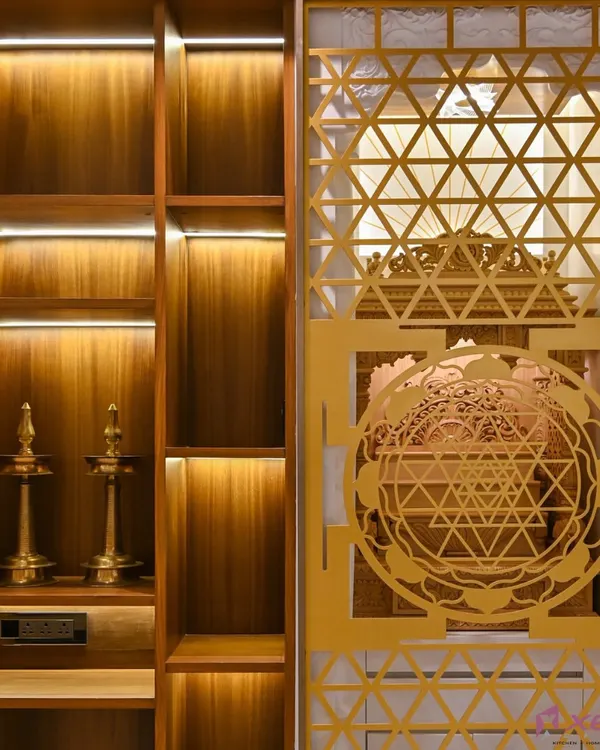 A tranquil corner for prayer and meditation. We designed this pooja unit with intricate geometric jali work on the door, which is beautifully highlighted by warm, integrated LED lighting. The wooden shelves provide ample space for idols and traditional lamps.
