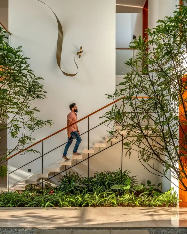 This is the Split House, a project where I focused on creating a seamless connection with nature. The floating staircase is surrounded by indoor plants and bathed in sunlight from a large skylight, turning a simple transition into a serene experience.