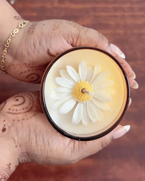 My signature daisy candle, held to show the beautiful detail of the wax flower on top. This is one of my most requested designs.