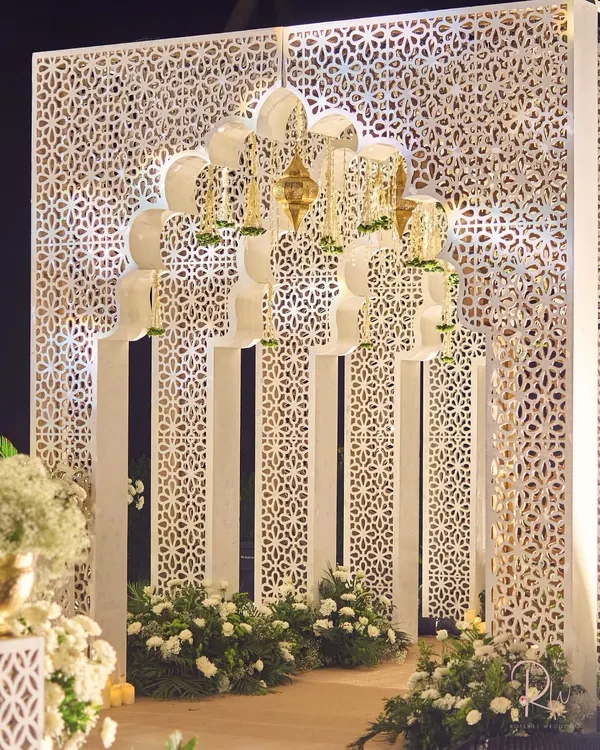 The entrance to the Sufi night featured a grand, multi-layered arch against a backdrop of intricate jaali screens. Hanging brass lanterns and floral details added to the Mughal-inspired aesthetic, creating a majestic first impression.