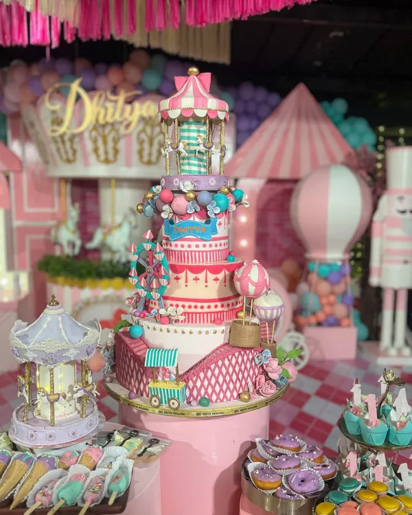 This is what a first birthday dream looks like. I designed this entire carnival-themed dessert table for little Dhitya, featuring a multi-tiered centerpiece cake with a ferris wheel and carousel, surrounded by custom cupcakes, macarons, and cakesicles.