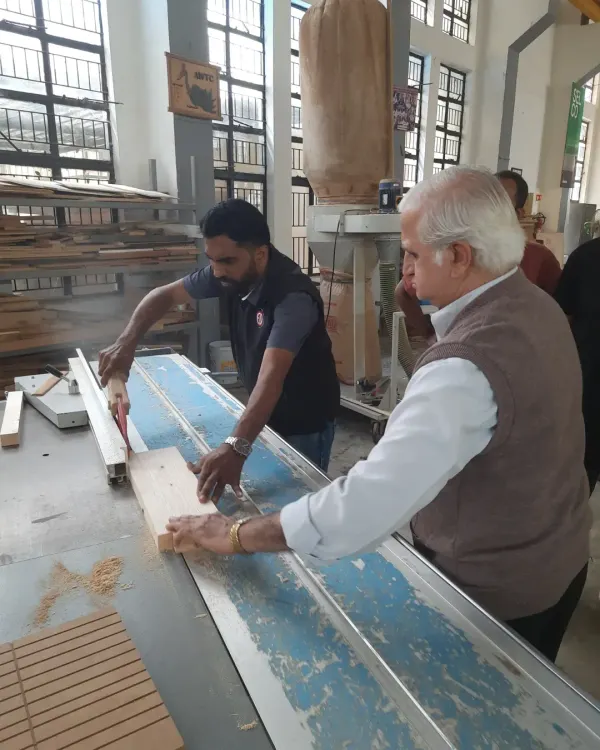 This is where learning happens. We provide close, hands-on guidance as students operate industrial-grade machinery like this panel saw, ensuring they build both skill and confidence safely.
