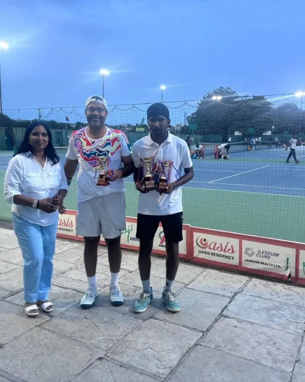 Coach Raju Muthukrishnan and a student with their trophies from the ITF World Masters Tour. We believe in a player-coach model where our mentors are also active, successful competitors.