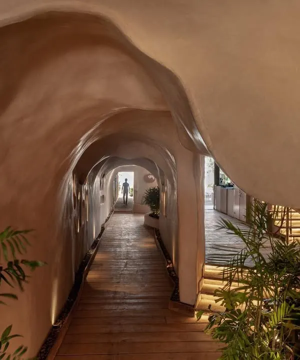 The entrance to Dubki in Goa was designed to feel like discovering a hidden cave. The fluid, ferro-cement walls and warm, low-level lighting guide you through a tunnel that opens up to the expansive view of the ocean, creating a dramatic sense of arrival.