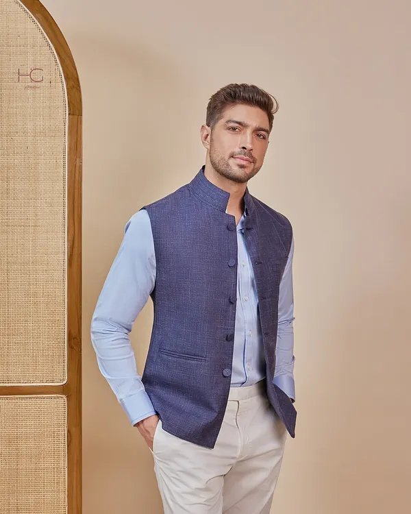 This is my modern twist on a classic style. A tailored navy Nehru vest is layered over a light blue shirt, creating a look that is perfect for festive occasions or formal events.