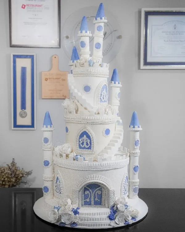 A truly regal creation, this multi-tiered castle cake with intricate piping and blue accents is perfect for a grand, fairytale celebration.