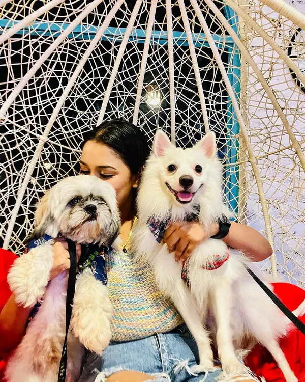 A happy mom with her two fur babies celebrating a birthday at our cafe. Our space is perfect for bringing the whole family together for a tail-wagging good time.