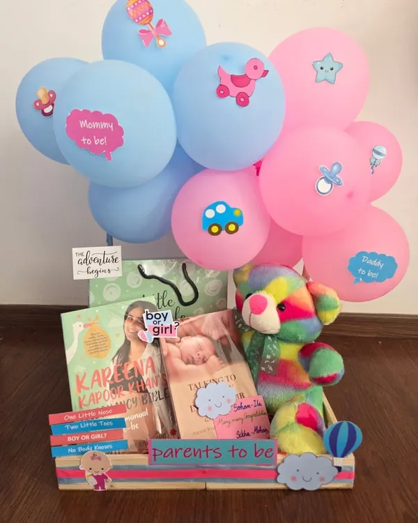 A perfect gift for expecting parents, this hamper includes pregnancy books like Kareena Kapoor's guide, a colorful plush toy, and fun 'Mommy to be' and 'Daddy to be' balloons. It's a celebration of the adventure ahead.