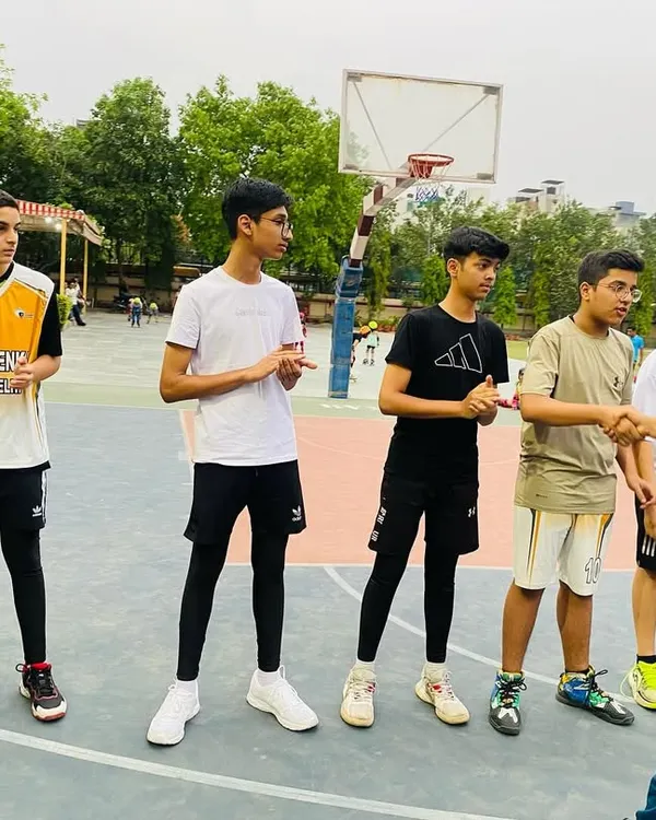 A coach gives instructions to the senior players before a match, discussing strategy and focus points.