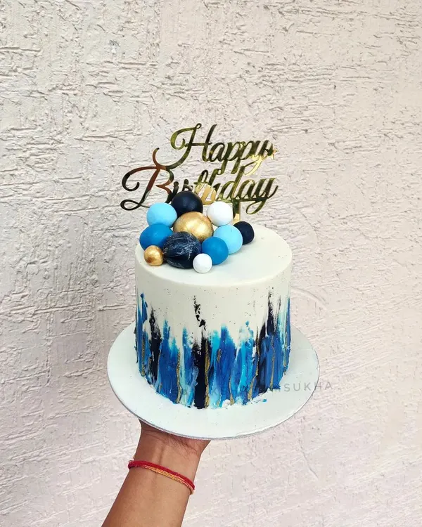 An abstract design for a modern celebration. I used a palette knife to create these bold blue and black brushstrokes on a white chocolate ganache base, topped with coordinating chocolate spheres.