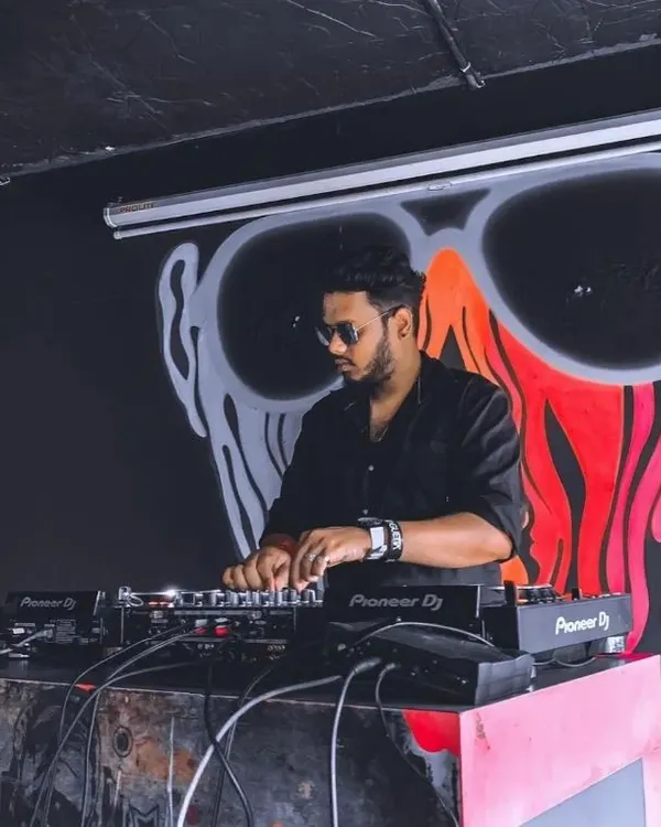 Spinning a set in a Bangalore club. The dark, moody lighting and cool graffiti art set the perfect stage for a night of deep house and hip hop music.
