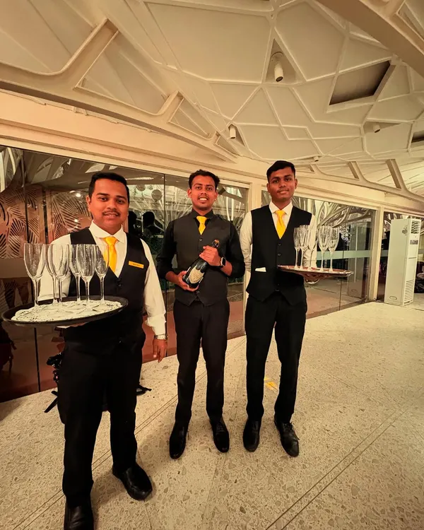 Our professional team at the Client Associates 20th-anniversary event. Dressed in smart uniforms, they are ready to serve champagne and welcome guests with a smile.