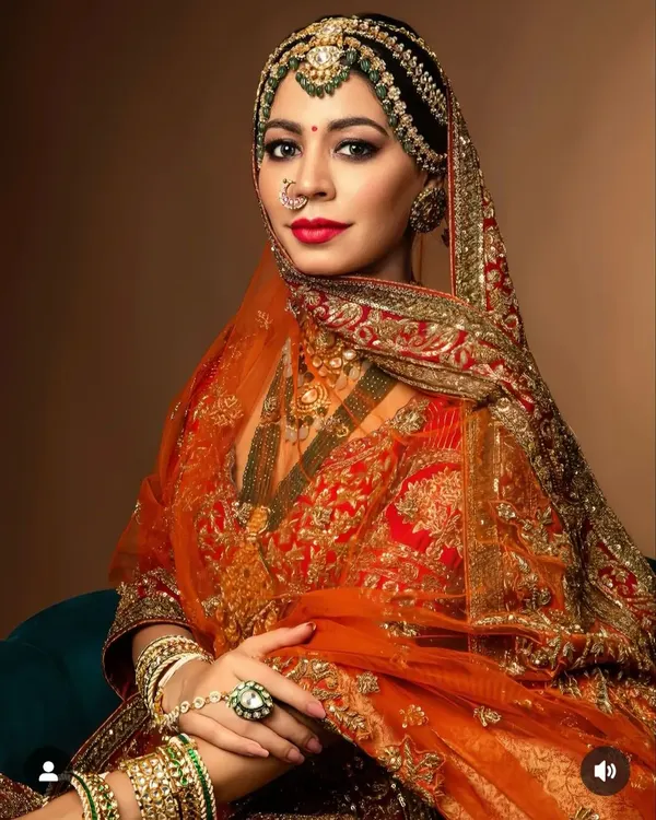 A regal bridal look featuring a traditional matha patti integrated into a sleek, center-parted bun. This style is perfect for securing a heavy dupatta while maintaining a classic and royal appearance for the main wedding ceremony.