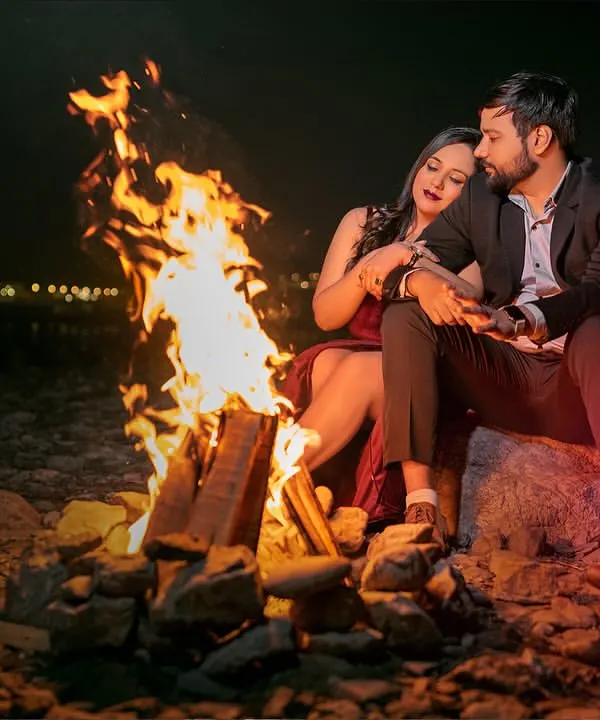 There's something incredibly romantic about a bonfire by the Ganga. The warm glow of the fire, the cool night air, and the city lights in the distance create a perfect setting for cozy, intimate couple portraits.