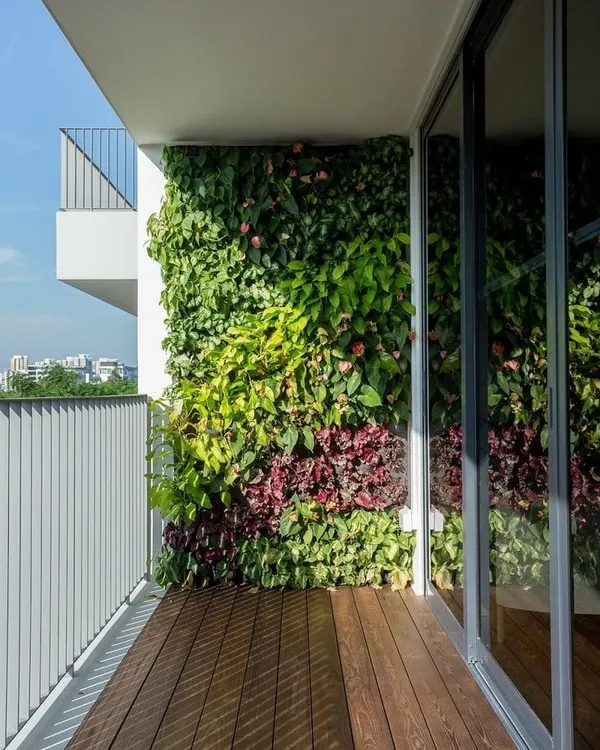 A stunning example of a residential vertical garden on a balcony. The mix of different leaf textures, colors, and flowering plants creates a rich, natural tapestry that enhances the view and purifies the air.