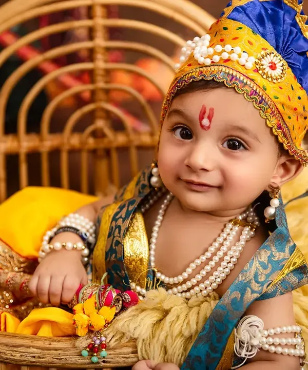 A portrait of a baby boy dressed as Little Krishna, complete with traditional jewelry and a peacock feather crown. This is an example of the unique and creative desi-themed photoshoots I offer in my studio.