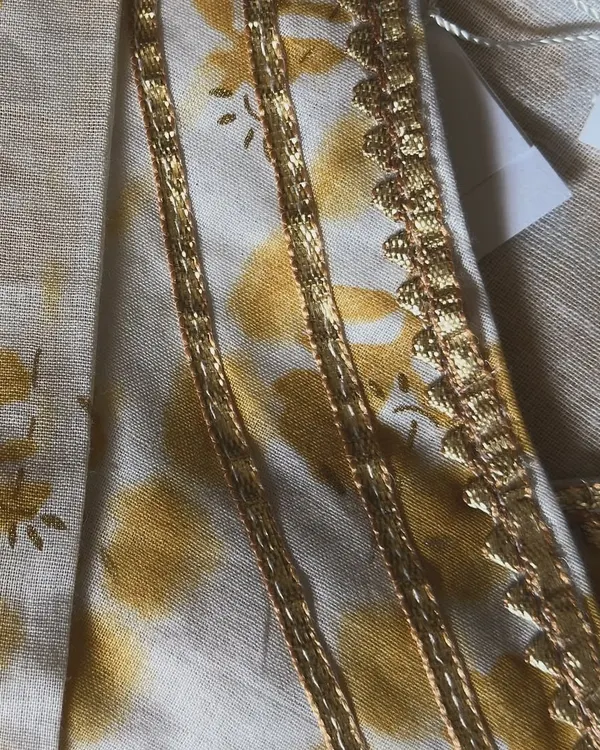A close-up of the delicate gold lace and tie-dye inspired print on our yellow angarkha set. It’s these little touches of bling that make an outfit festive.