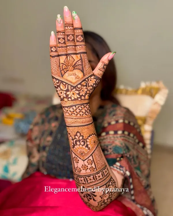 A beautiful backhand design for a bride, with her name 'Priyanka' subtly included. The pattern is a mix of floral motifs and traditional bands.