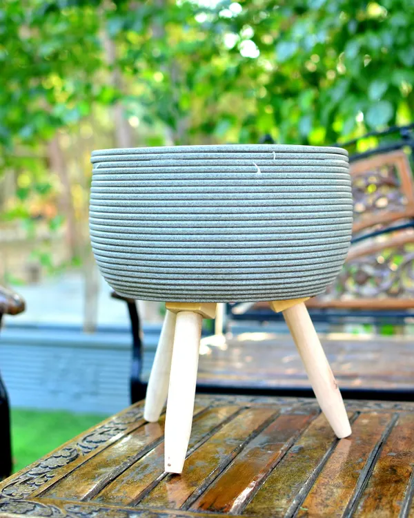 This textured planter with a mid-century modern wooden stand is one of my most popular items. It elevates the plant off the floor, giving it more presence and fitting perfectly with contemporary home decor.