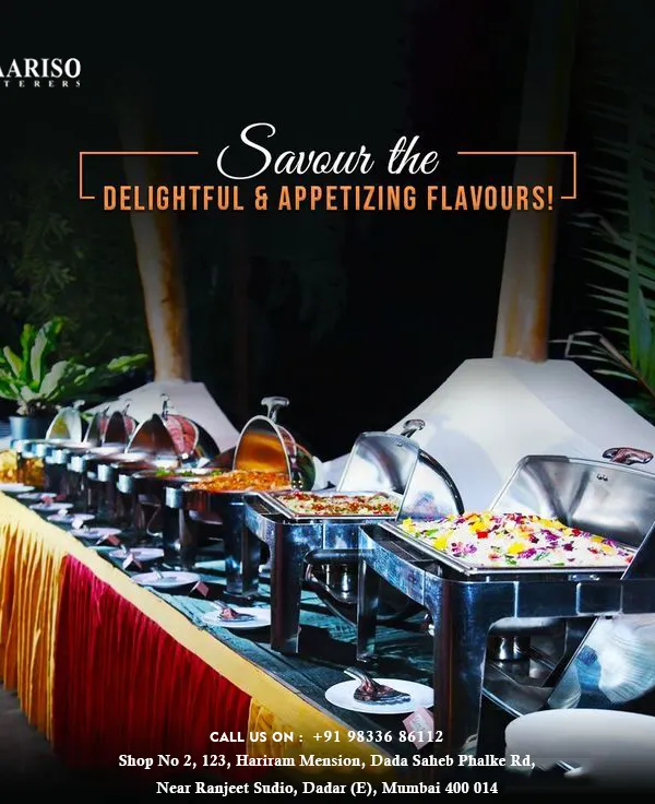 An evening buffet setup for an outdoor event, featuring a long line of stainless steel chafing dishes ready to serve a variety of hot dishes. This arrangement ensures food is kept at the perfect temperature for guests to enjoy throughout the celebration.