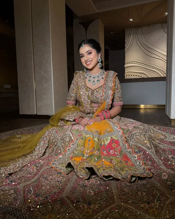 A bride seated in her magnificent multi-colored lehenga. I draped the dupatta to fall gracefully, complementing the grandeur of the skirt.