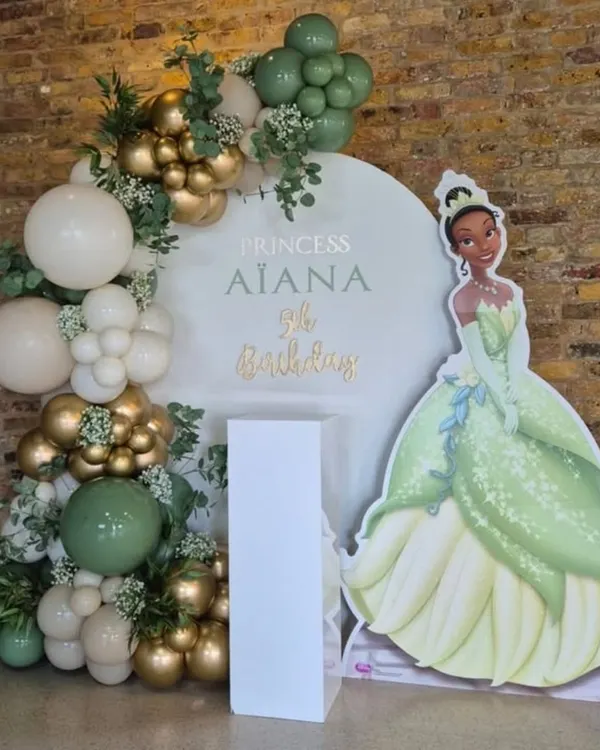 A royal celebration for Princess Aiana's 9th birthday with a Princess Tiana theme. The elegant green, gold, and white balloon arch perfectly complements the character cutout.