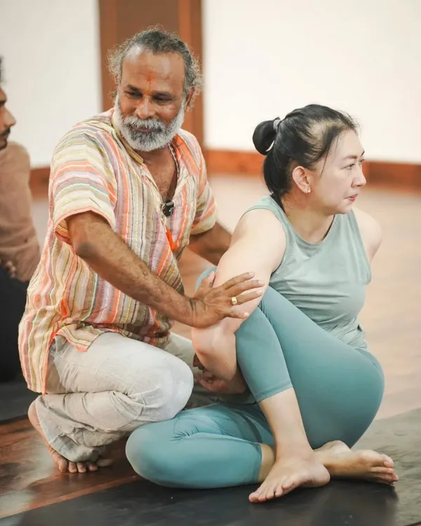 This is the heart of my practice: guiding you with hands-on assistance to find safe alignment and a deeper understanding of the pose. Here, I am helping a student find space and ease in a seated twist.