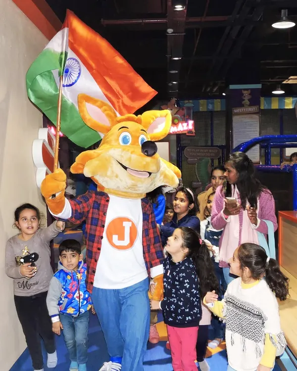 J the Fox leads the parade during our Independence Day celebration, waving the flag with pride.