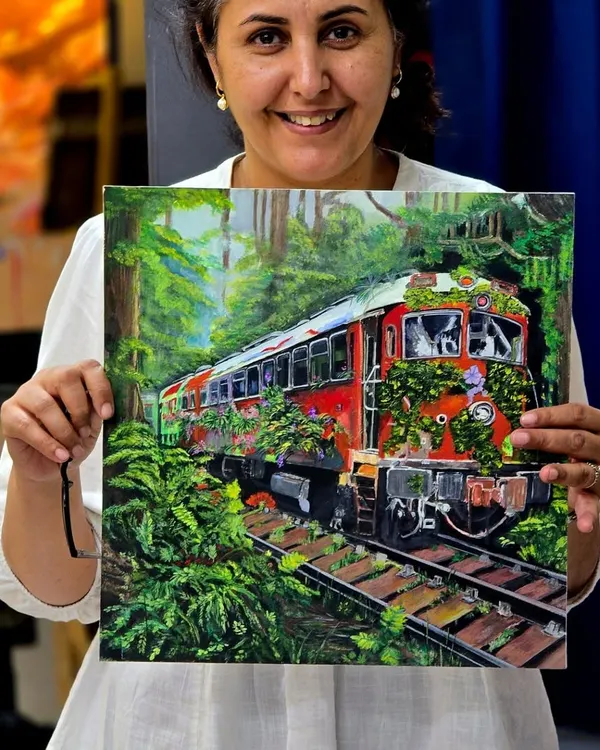 A proud student holding her finished gouache painting. This piece captures an abandoned train being reclaimed by nature, a testament to the narrative and detail we encourage in our landscape and subject painting courses.