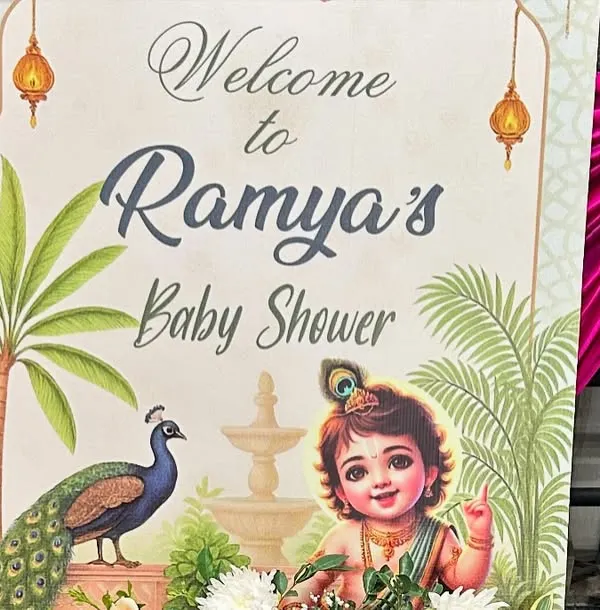 A traditional and artistic welcome sign for a baby shower, featuring a beautiful illustration of baby Krishna and a peacock.