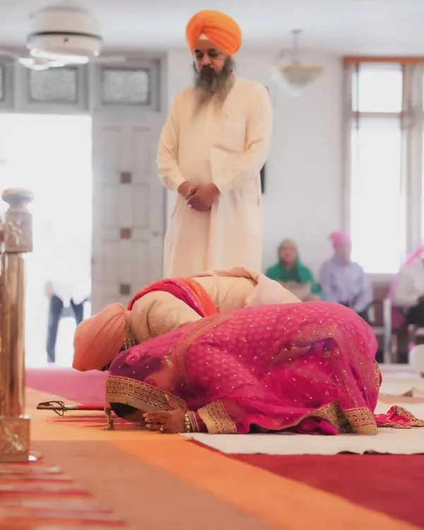 A moment of deep respect and prayer during an Anand Karaj ceremony. I capture these solemn moments from a low angle to emphasize the sanctity of the space.