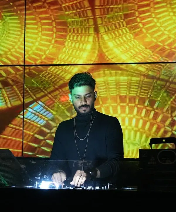 Focused on the mix, with a backdrop of spiraling, warm-toned geometric visuals on the LED screen. As a VDJ, I ensure the visuals are as dynamic and engaging as the progressive house and techno music I play.