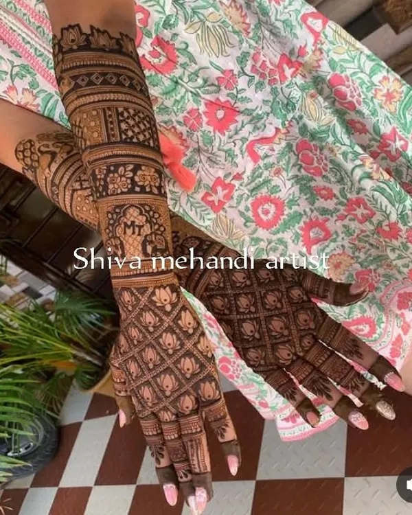 A modern take on a traditional pattern, this design features a full jaali (net) pattern made of lotus buds. The forearm includes an elephant motif and a personalized initial 'M'.